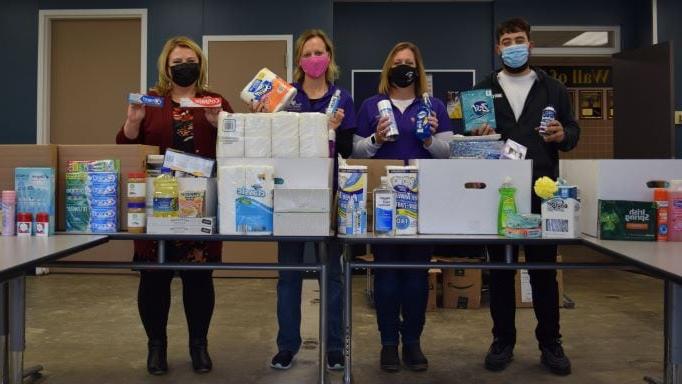 4 people standing with kitchen & toiletry items